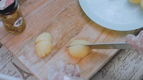 Die Küchenchefin schneidet Kartoffelscheiben zum Braten oder Schmoren von Hand ab. Teil des Garvorgangs