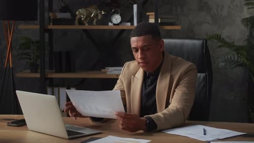 Man Reviews Documents in Office Setting