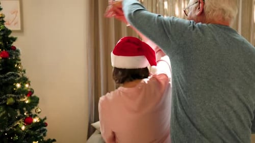 Festive Senior Couple Dancing at Christmas Indoors