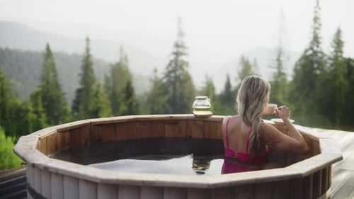 Blonde Woman Relaxes Taking Hot Tube at Mountain Eco Resort