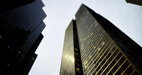Los imponentes rascacielos reflejan la luz solar en un entorno urbano durante el día