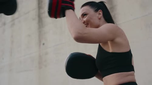 Woman Boxing and Exercising with Punching Pad