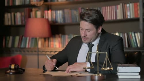 Pensive Male Lawyer Writing Documents in Office