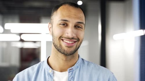 Portrait of happy African American businessman standing in business office. Smiling black man posing