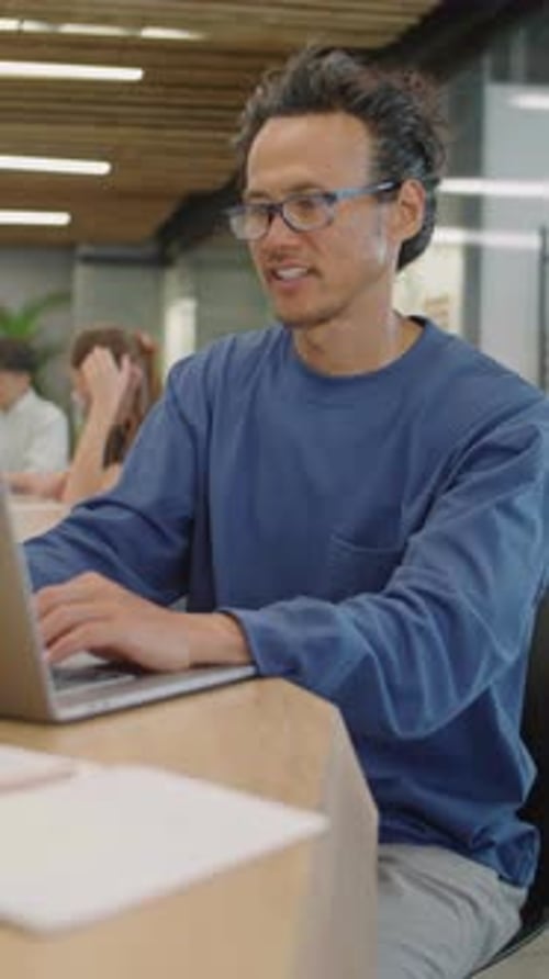 Asian Man Working on Laptop in Office