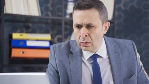 Worried Man Using Computer in Office Setting