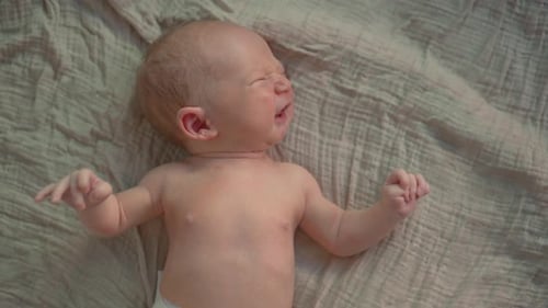 Close Up of an Infant Crying on a Blanket
