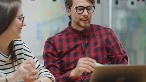 Office workers collaborate on project with laptop computer