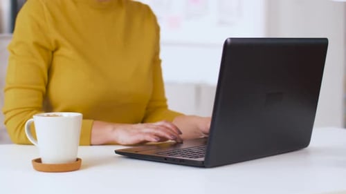 Woman Works At Laptop And Drinks Coffee