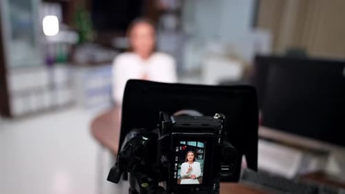 Camera Filming Woman in White Jacket in Office