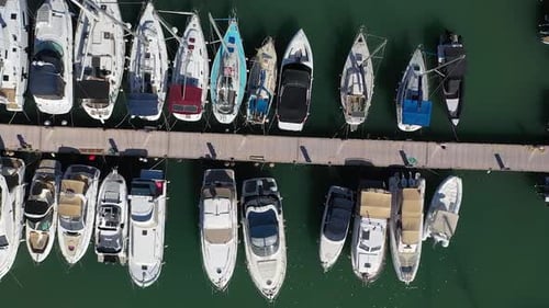 Sailing boats and luxury yachts moored at port, aerial overhead view