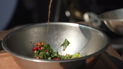 Slow Motion Of Vinaigrette Being Poured Onto Salad In A Bowl. close up