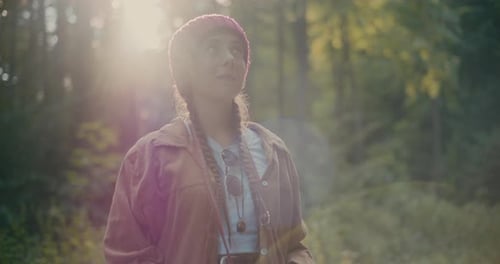 Female Hiker Using Binocular Standing In Woods