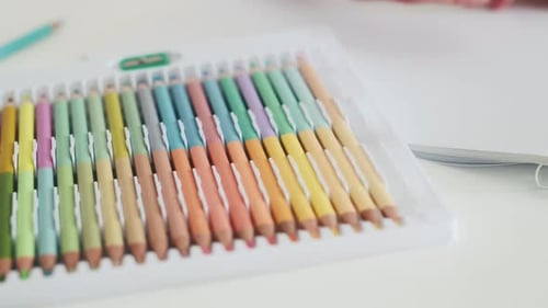 Hand Selects Colored Pencil to Draw in Notepad