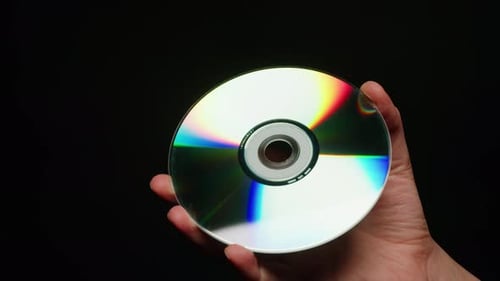 CD Disk in Hands on Black Background Closeup Old Vintage Disks for DVD Player or Computer Music