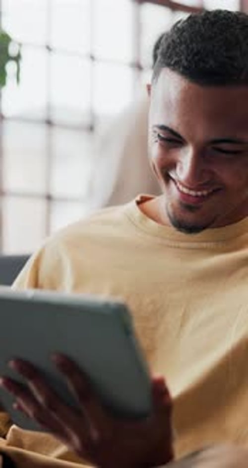 Smiling Man Using Tablet Indoors in Natural Light