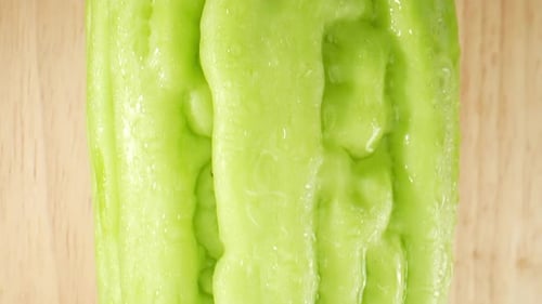 Dans une vidéo macro, une courge amère chinoise scintille sous l'effet de gouttelettes d'eau