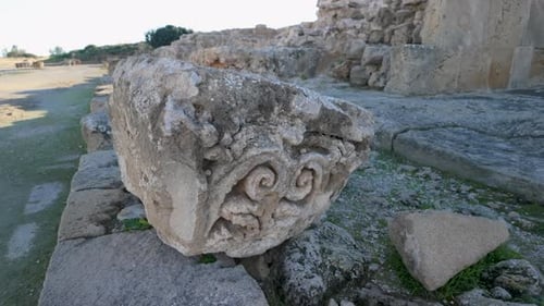 Un gros plan d'un fragment de pierre orné sur le site archéologique de Nea Paphos, montrant des détails d'environ