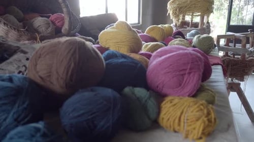 Slow push in shot revealing various colours of balls of yarn