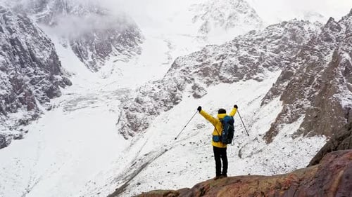 Hiker Celebrating Reaching the Snowy Mountain Peak