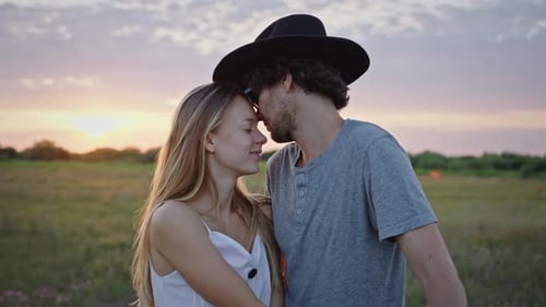 Couple Kissing at Sunset in Field
