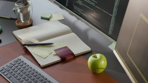 Schreibtisch für Programmierer mit laufendem Programmcode auf dem PC-Bildschirm