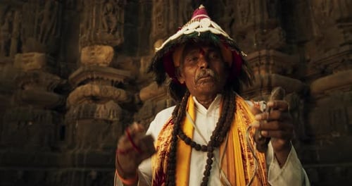 In an Ancient Hindu Temple, a Close-Up Portrait Features an Old Indian Man Adorned in Traditi