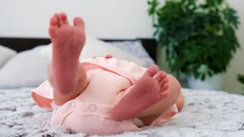 Tiny Feet of Baby Lying on Bed