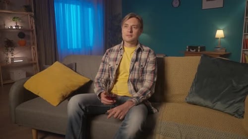 Man Holding Wine Glass Sitting on Sofa