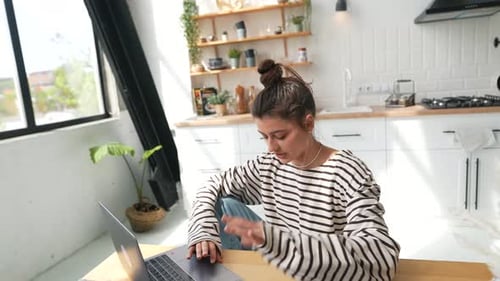 A Young Beautiful Girl is Working Online with Her Laptop and Having a Conversation