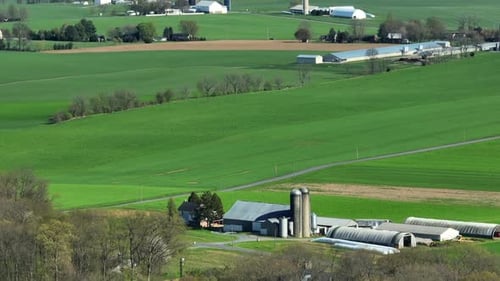 Drone wide shot showing many farms in rural area of Illinois, USA. Beautiful sunny day with green fi