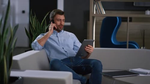 Man Uses Tablet While Talking on Mobile Phone
