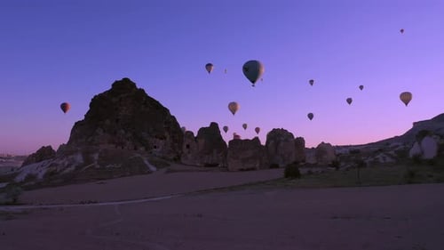 Hot Air Balloons Floating Over Desert Landscape at Sunrise