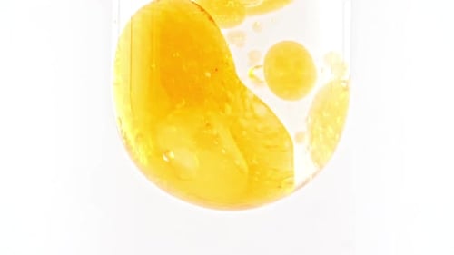Yellow Liquid Blobs Dropping into Clear Fluid