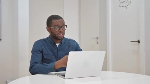 Man On Video Call Using Laptop In Bright Room