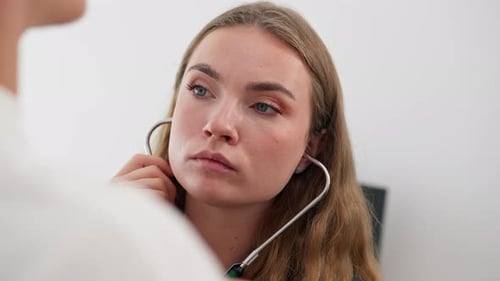 Close Up in a Modern Clinic in a Small Therapist s Office a Young Girl Doctor with a Stethoscope