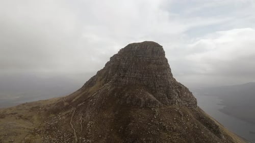Vue aérienne par Drone tournant dans le sens des aiguilles d'une montre de la montagne Stac Pollaidh et des nuages au-dessus de celle-ci en Écosse