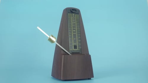 Klassisches mechanisches Metronom in einem holzähnlichen Gehäuse.