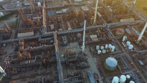 Aerial view of oil refinery and power plant with pipelines and storage tanks.