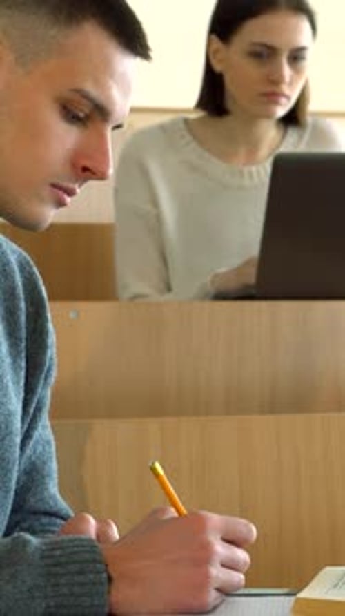 Focused Student Taking Notes in Class