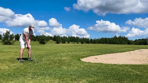Professional golf player prepare near sand bunker, scenic summer sky, Latvia