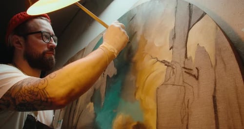 Male Artist Paints a Canvas in His Art Studio