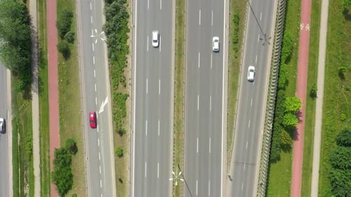 Top view of freay road. Clip. Highway with traffic in forest. Suburban highway with cars and trucks.