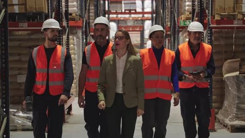 Female Supervisor Leading Warehouse Workers During Inspection
