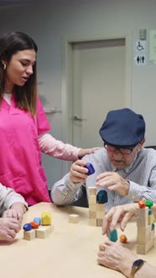 Elderly Man Building with Blocks in Slow Motion with Nurse