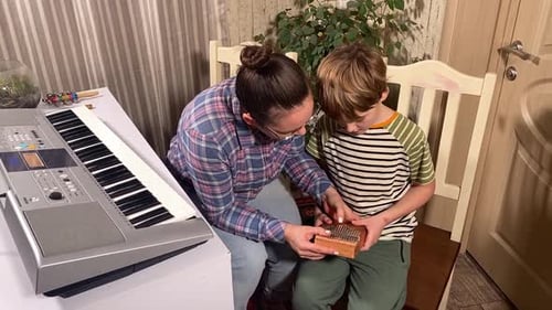 Woman and Boy Play Kalimba Together at Home