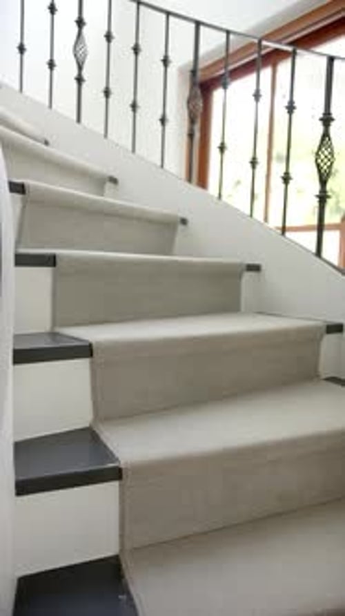 Vertical video of spiral staircase in hallway of luxury home, slow motion