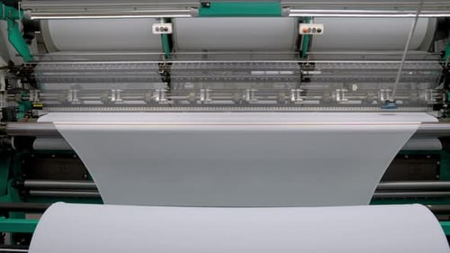Automated Machine Weaving White Fabric in Factory Setting