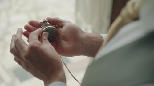 Elegant Man Holds Antique Pocket Watch By Window