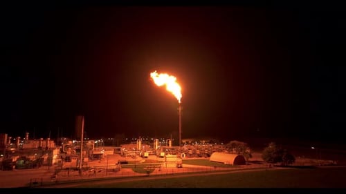 The Entire Plant is Illuminated as a Result of Gas Flaring - Drone Flying Forward